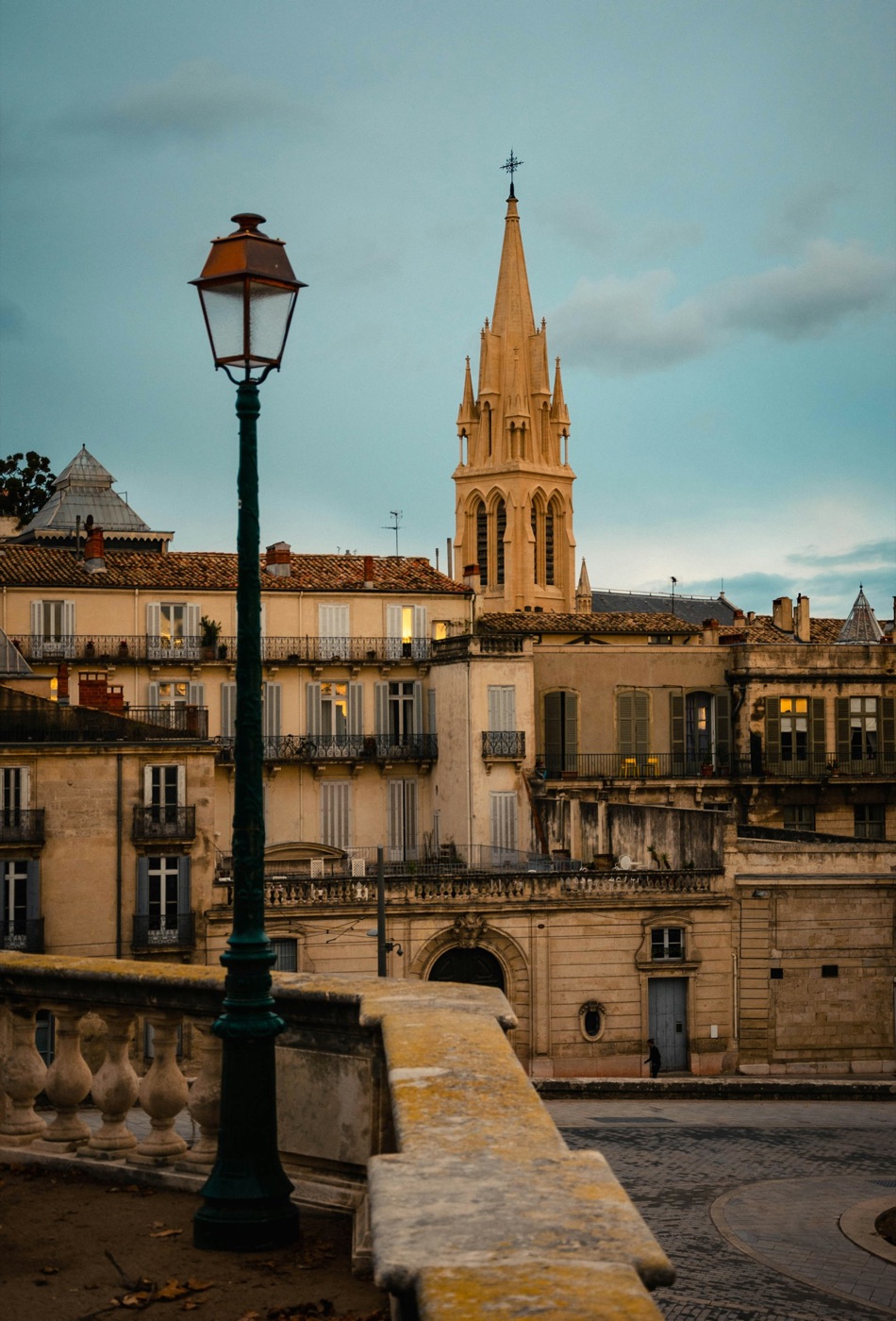 A street lamp and the spire of Sainte-Anne church above the old town of Montpellier